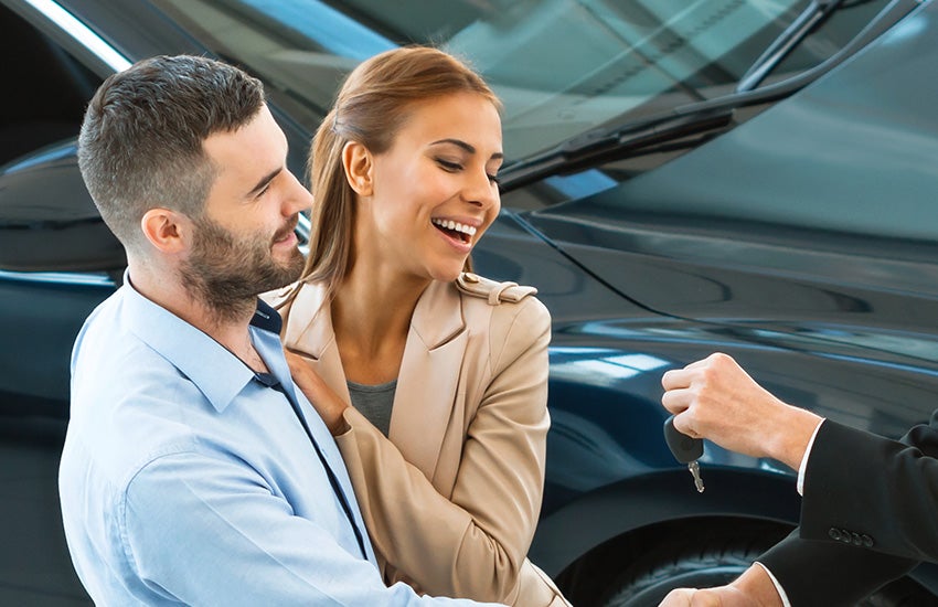 Mechanic and customer smiling while reviewing a service order.